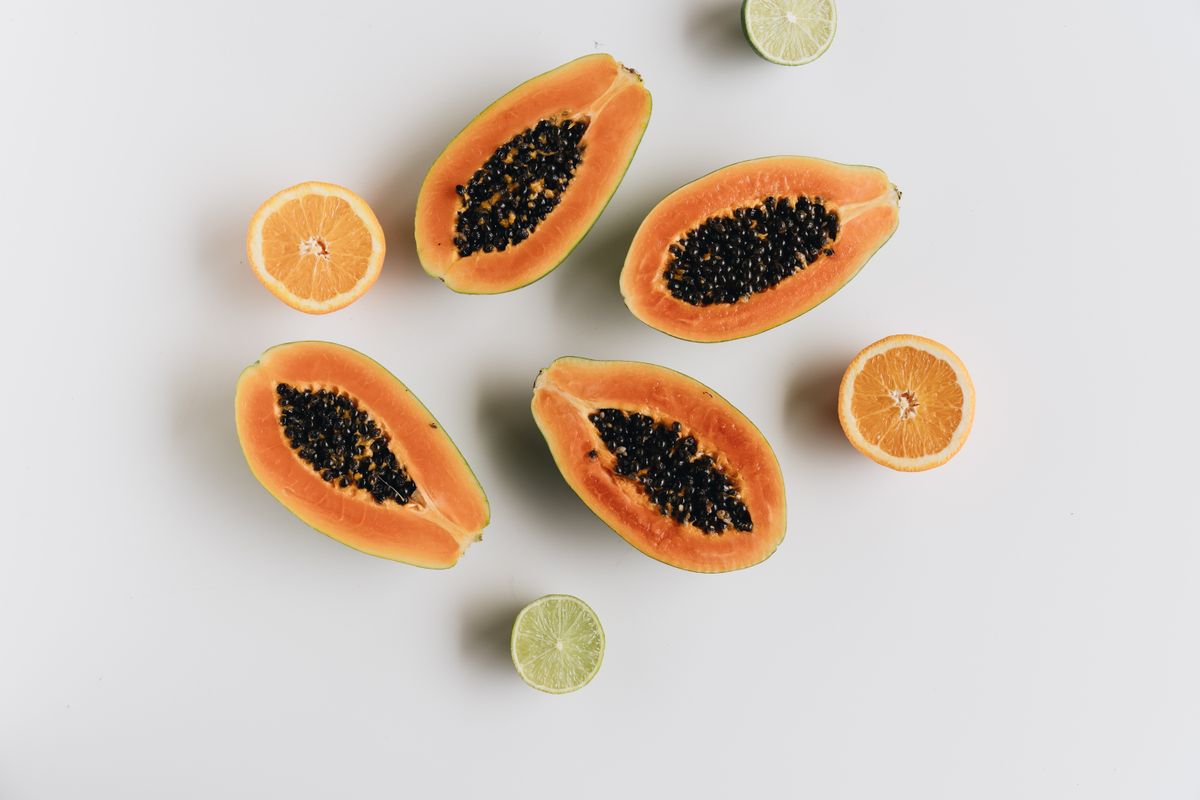 Papayes et citrons verts sur fond blanc