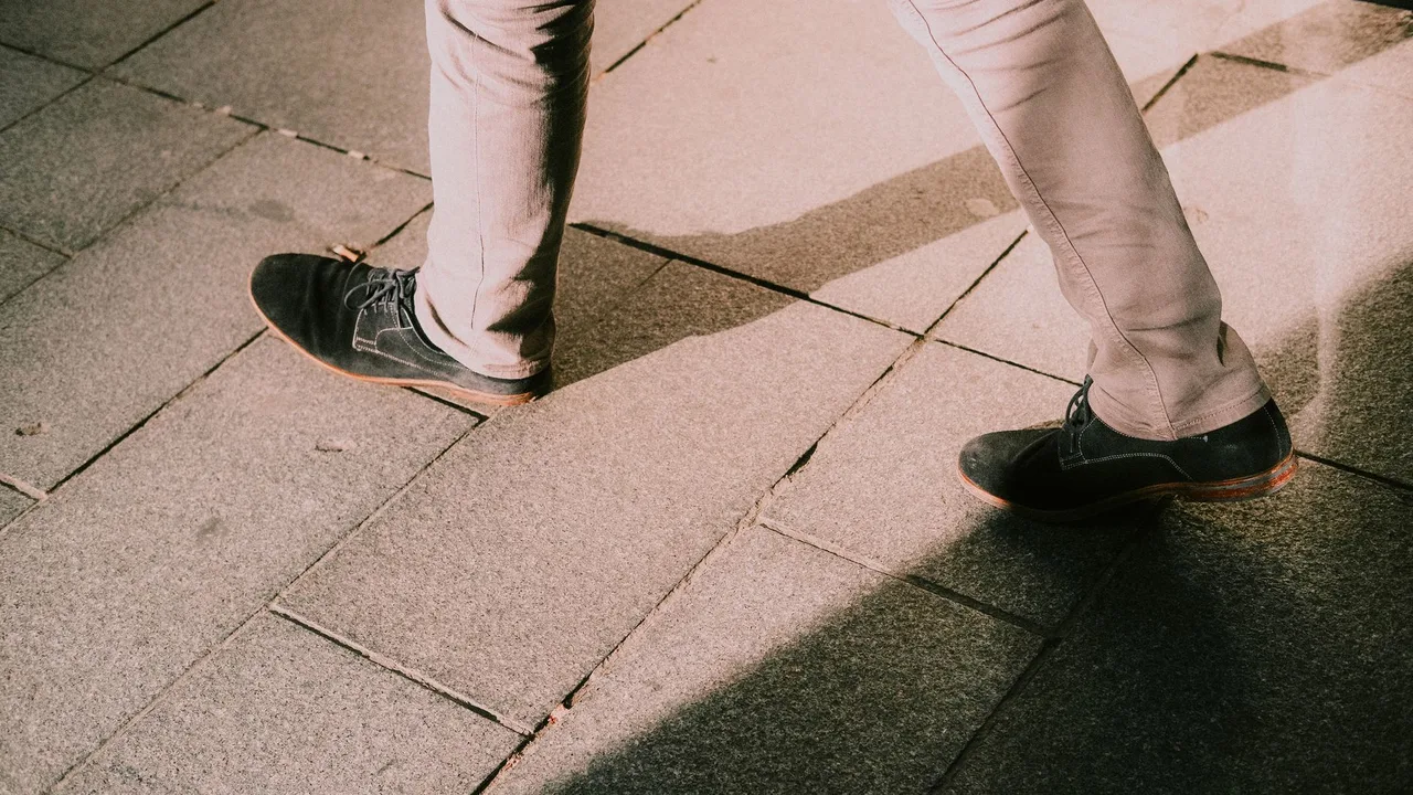 Jambes en marche sur un pavé illustrant l'importance de l'activité pour la circulation veineuse