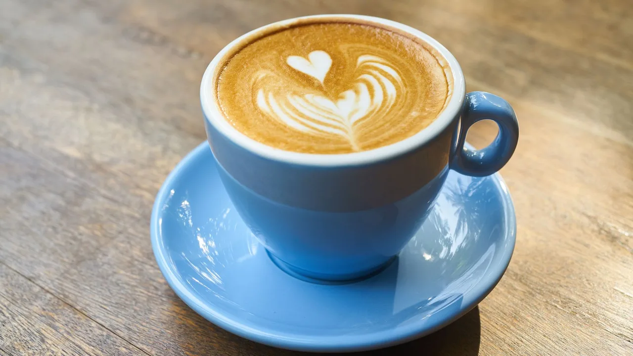 Tasse de café avec art latte en forme de cœur sur une table en bois