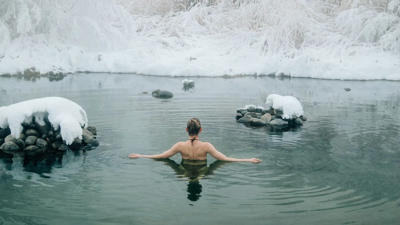 Femme nageant dans un lac hivernal entouré de neige — exposition au froid et santé