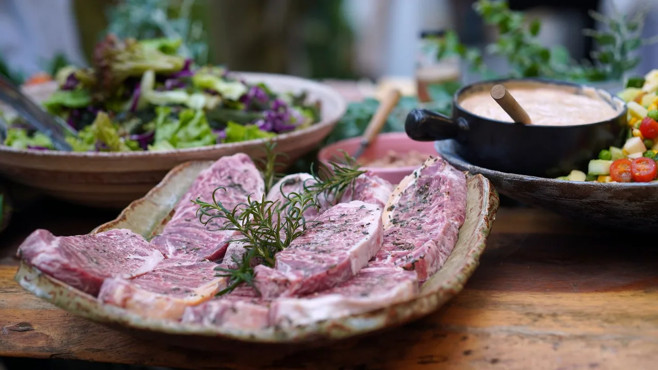 Viande de boeuf crue de qualité sur un plateau, garnie de romarin frais