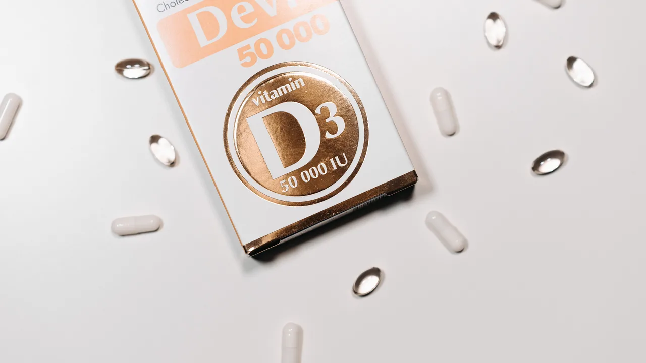 Complément de vitamine D3 en gélules sur fond clair